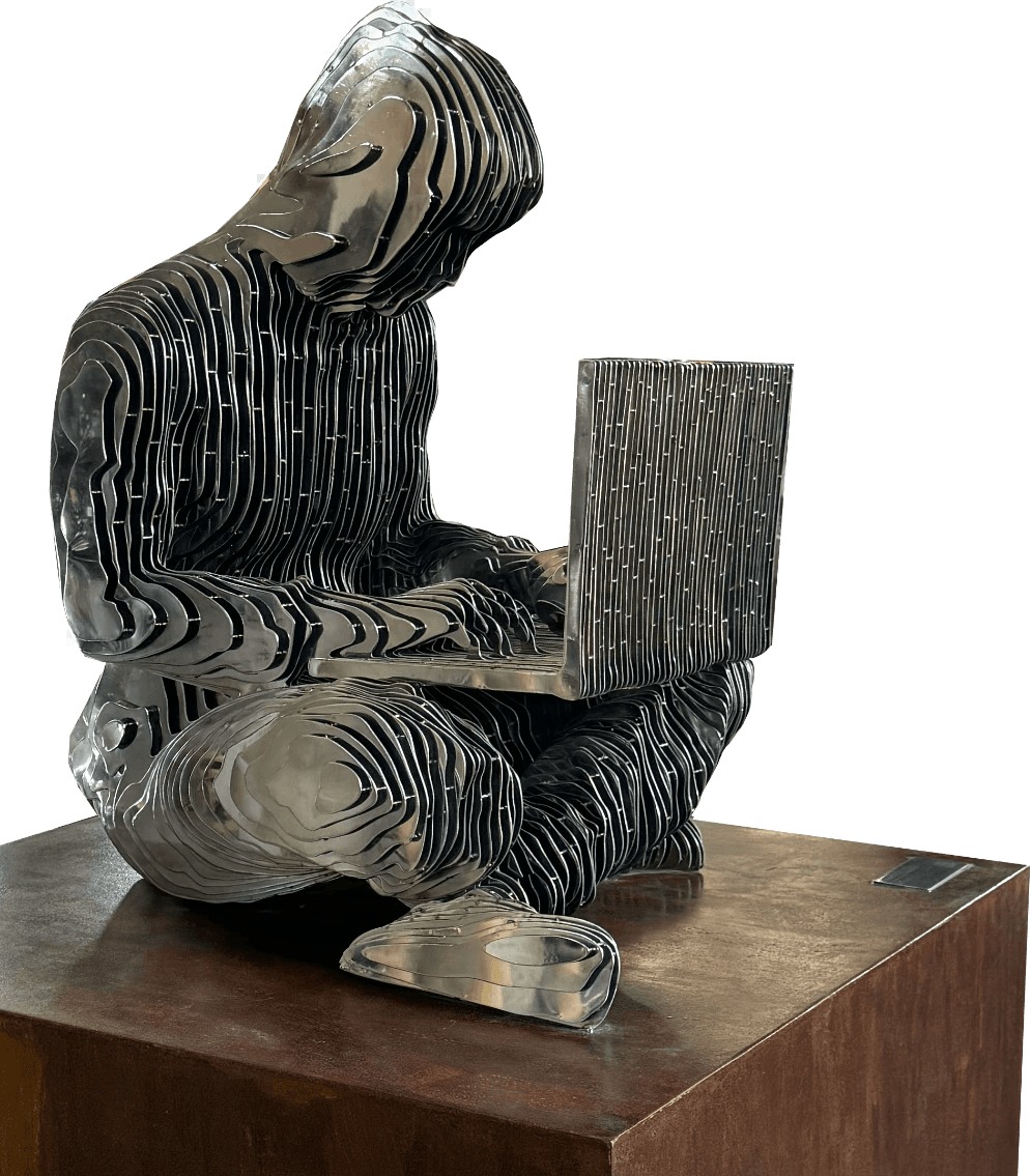 A faceless figure working on a laptop